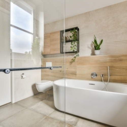 Moderne badeværelse efter renovering på Fyn med fritstående badekar og lyse fliser