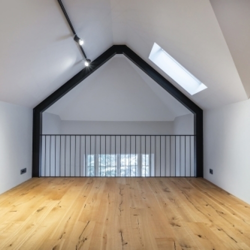 Renoveret tagetage i Bogense med lyst trægulv og loftsvindue