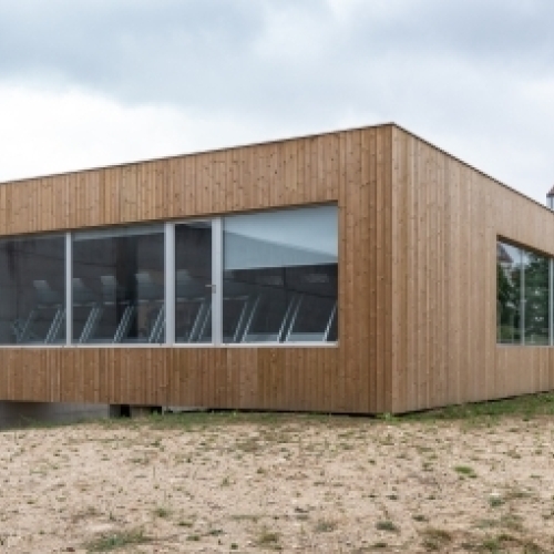 Moderne tilbygning på Fyn med træfacade og store vinduespartier