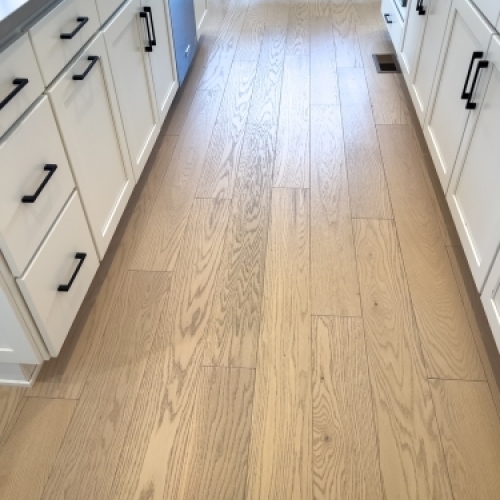 Lyst trægulv i køkken efter renovering på Fyn med moderne køkkenelementer