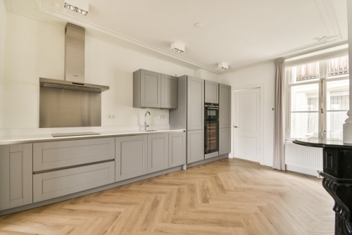 Renoveret køkken i Trekantsområdet med sildebensgulv og lyse køkkenelementer