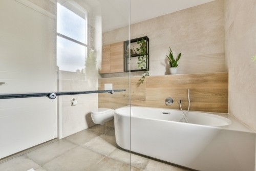 Moderne badeværelse efter renovering på Fyn med fritstående badekar og lyse fliser