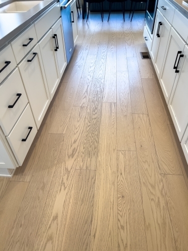 Lyst trægulv i køkken efter renovering på Fyn med moderne køkkenelementer